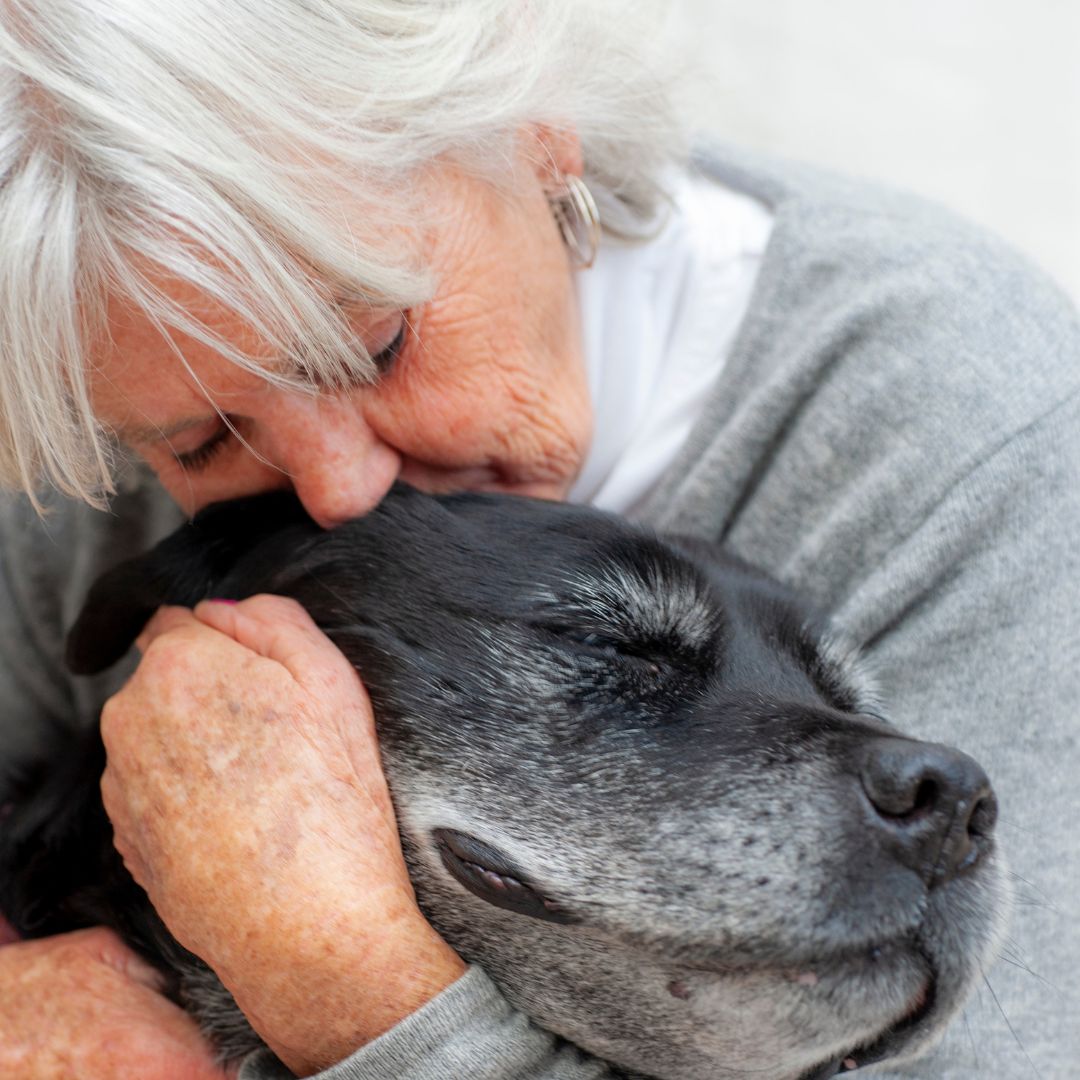 Woman gently kisses her dog